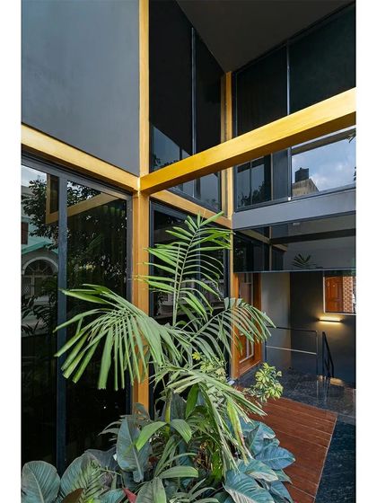 Another perspective of the internal courtyard in the 'SOL' residence, showing how the structural frame and large glass panels create a light-filled, multi-story volume that connects different levels of the home.
