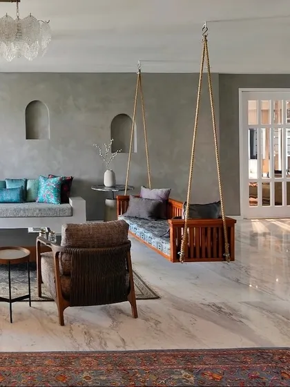 For this Delhi residence, we introduced a traditional wooden swing into a contemporary living space defined by cool grey lime-plastered walls and polished marble floors. This adaptive reuse project focuses on creating a harmonious balance, where modern minimalism is softened by familiar, tactile elements that evoke a sense of calm and playfulness.
