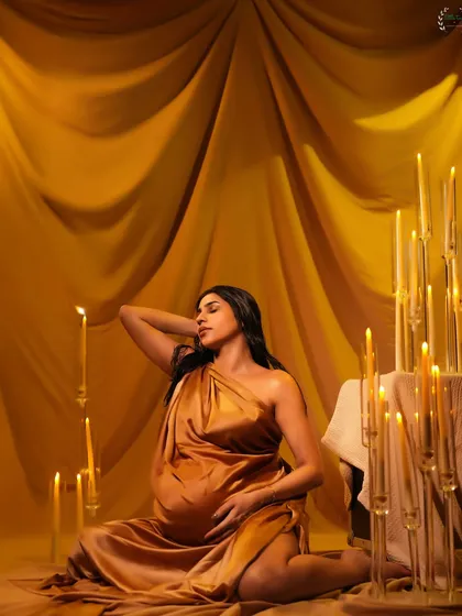 Another angle of Pria's stunning candlelight maternity portrait, highlighting the golden tones and elegant draping.