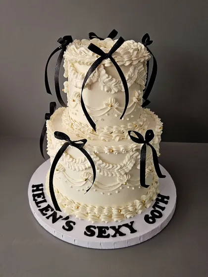 This one is for the lovers of all things classic. A two-tier vintage Lambeth cake with intricate buttercream piping and delicate black ribbon bows. This style is all about elegance and old-world charm, making it an *ati sundar* choice for a milestone birthday or chic celebration.