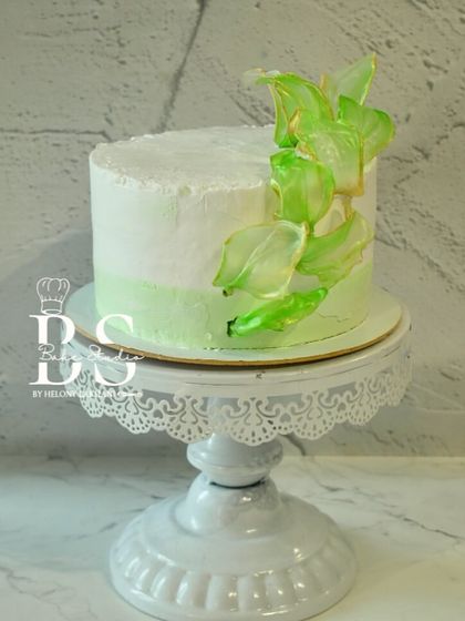 A finished masterpiece from our whipped cream module. This cake features a clean, minimalist design with a pop of color from the edible sails, a popular modern cake decorating technique.