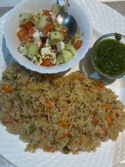 A wholesome meal of vegetable pulao, a side salad of cucumber, tomato, and paneer, and a vibrant green chutney. This is part of a live diet consultation plan designed for fat loss.