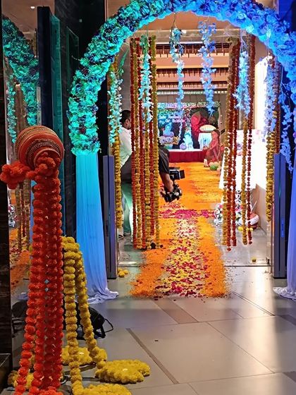 A grand entrance decoration for a Krishna-themed naming ceremony. The floral archway and marigold garlands create a traditional and welcoming path for guests.