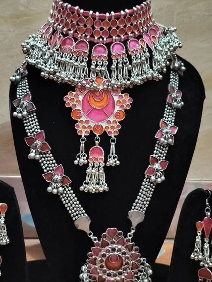 A pink and red themed oxidised silver set, offering a unique color palette for festive wear.
