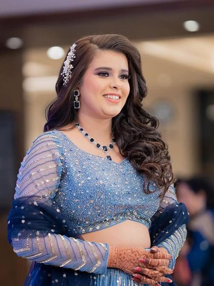 A happy and bright look for a Sangeet, featuring a sparkling blue lehenga and a pretty hair accessory.