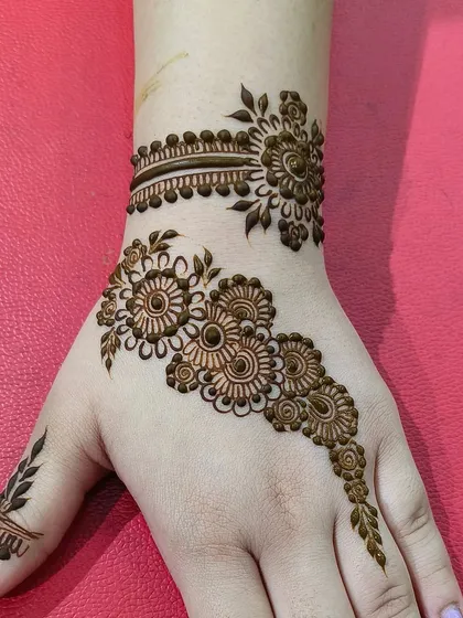 A beautiful example of a 'hathphool' or hand jewelry style. The design features a wristband connected to a floral pattern on the back of the hand, mimicking a traditional ornament.
