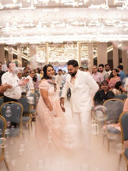 Another shot of the couple's grand entrance, surrounded by family, bubbles, and a magical cloud of fog. It’s a moment straight out of a fairytale.