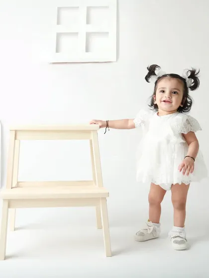 Standing tall and looking adorable with her two little pigtails. A simple, beautiful portrait from a first birthday session.