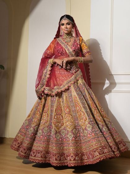 A full-length view of the bride in her magnificent multi-colored lehenga. The makeup is designed to complement the grandeur of the outfit perfectly.