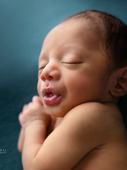 A sleepy yawn from a newborn against a deep teal backdrop. This unposed moment captures the realness and vulnerability of a baby's first days.