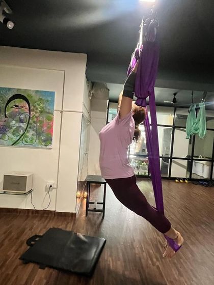 Using the silk hammock to assist with a deep stretch. The support of the fabric allows for a greater range of motion and helps release tension in the shoulders and back.