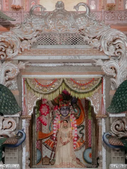 Radhika standing before the magnificent Shrinathji deity. This powerful image connects the spiritual and the personal, showing a moment of reverence and peace before the wedding ceremony begins.