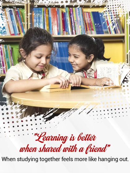 Learning is always better when shared with a friend. Two students collaborate in the library, turning study time into a moment of shared discovery.