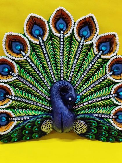 A stunning peacock-shaped Diya decoration, intricately painted and embellished. Perfect for learning festive crafts before Diwali.