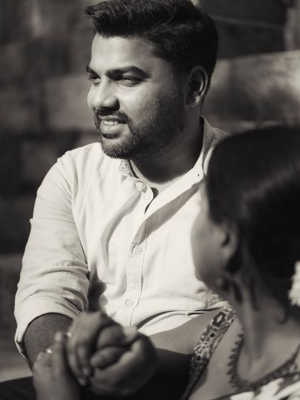 A black and white candid shot focusing on the groom's loving gaze. It’s a quiet, observant moment that speaks volumes about his feelings.
