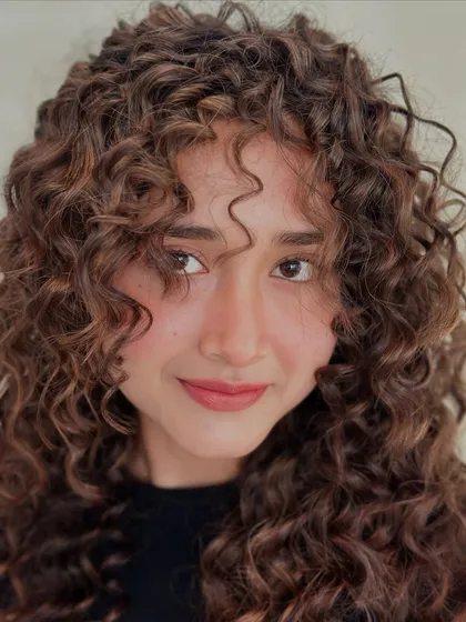 These curls don't follow rules, they make them. A close-up shot of beautifully defined, colored curls.