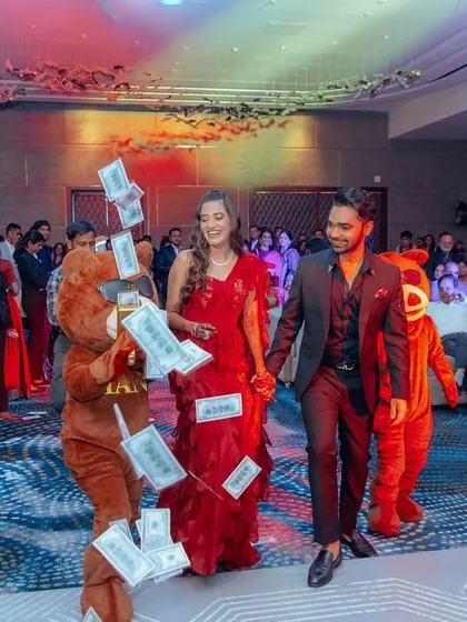 For a fun, themed cocktail night, the couple entered with mascots shooting fake money, creating a playful and high-energy start to the party. I believe in entries that reflect the couple's personality.