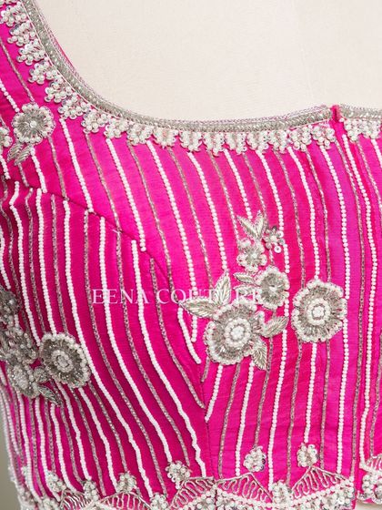 Pretty in pink, this raw silk blouse features intricate pearl and silver thread work in a striped pattern. I added floral motifs and delicate danglers on the sleeves for a touch of playful elegance.