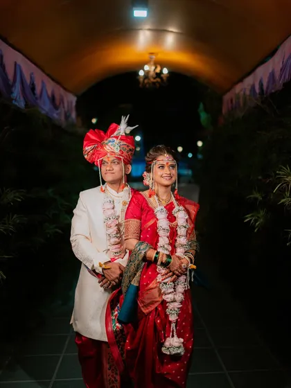A classic, formal portrait of the bride and groom in their traditional Maharashtrian wedding attire.