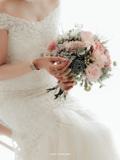 A close-up of the bride's hands holding her bouquet, a simple yet elegant detail shot.