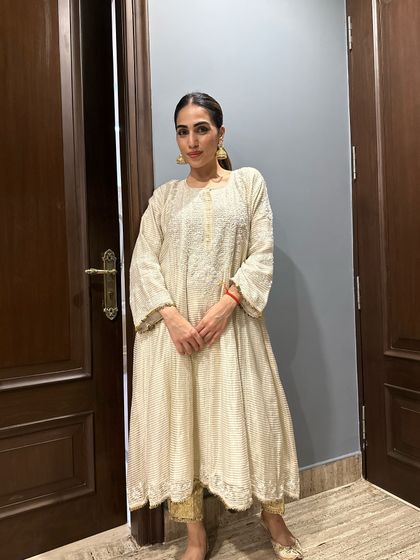 A full view of this elegant off-white Anarkali suit. The long, flowing silhouette is flattering and perfect for any festive occasion.