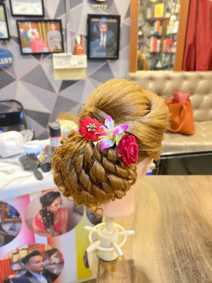 A beautiful floral bun created by a student at my academy. This style combines a classic twisted bun with delicate flower accessories, perfect for a wedding guest or bridesmaid.