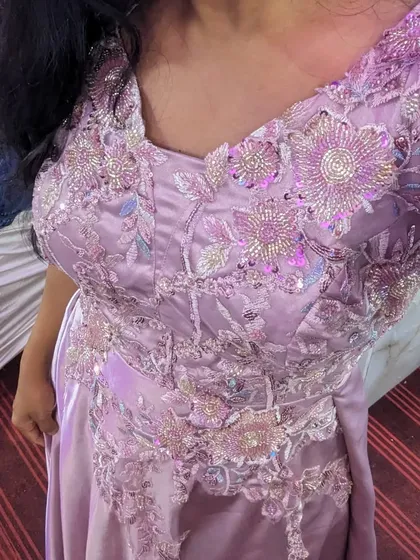 A close-up of the beautiful embroidery on this pastel pink gown. It's a simple yet elegant choice for a party, available to rent or buy.