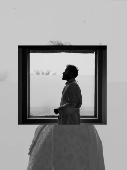 An artistic silhouette of the groom, framed within a window, showcasing our creative approach to groom portraiture.