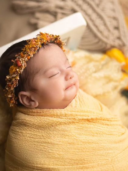 A sweet, contented smile from this little one wrapped in sunny yellow. You can just feel the happy dreams she is having.