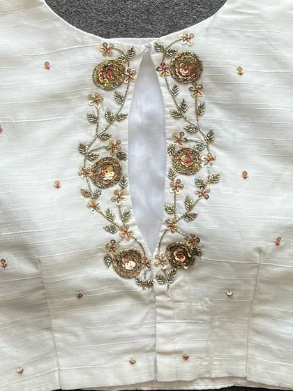 The back of my handwork ready-to-wear blouse in white Elzara silk, featuring a keyhole opening and intricate sequin and thread embroidery.