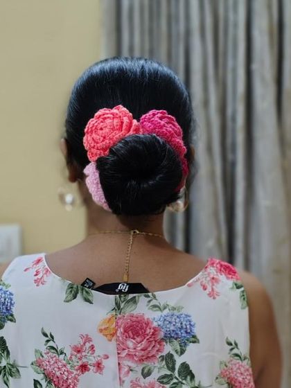 A customer looking beautiful with our multi-colored rose gajra styled around her hair bun.