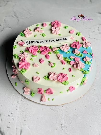 A special slice for a celebration. This cake features a beautiful abstract design with pink flowers against a splash of blue.