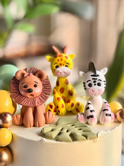 A detailed shot of the fondant lion, giraffe, and zebra, each one carefully crafted to add personality to the jungle cake.