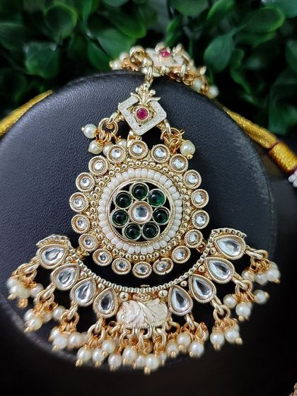 The maang tikka designed to go with this set, featuring a large circular design that mirrors the necklace.