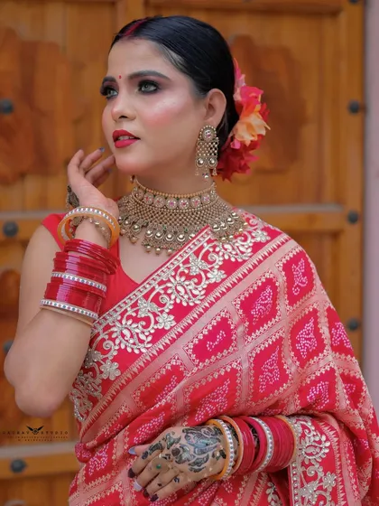 A close-up portrait focusing on the model's expression and the details of her henna and jewelry.