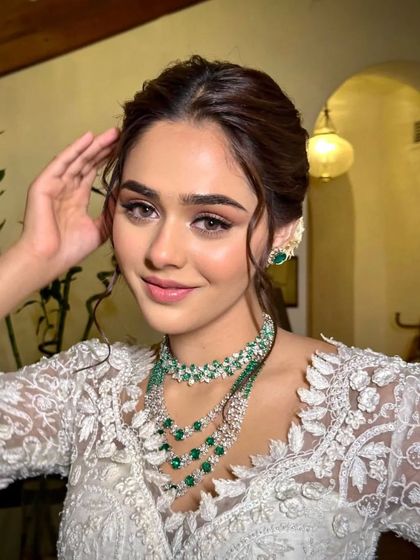 Presenting Husn. A delicate white lace saree paired with a stunning emerald and diamond necklace.