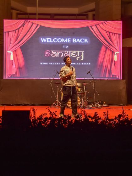 The stage setup for Aditya Kullu's show at IIM Vizag, featuring a large LED screen and professional stage.