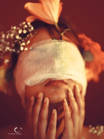 A pose that suggests struggle or confusion, adding a layer of emotional depth to the blindfold concept.