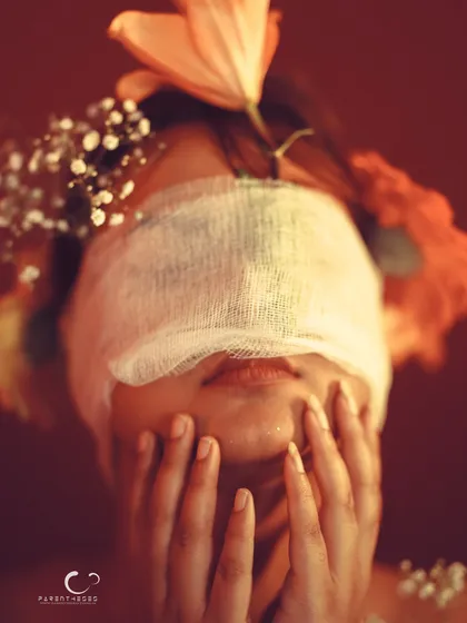 A pose that suggests struggle or confusion, adding a layer of emotional depth to the blindfold concept.