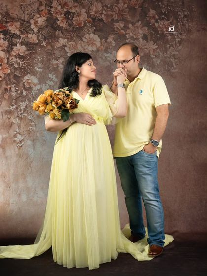 A chivalrous kiss on the hand. This romantic pose, paired with a lovely yellow gown and a floral backdrop, creates a fairytale-like moment for your maternity album.