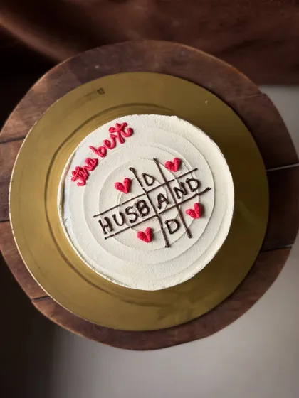 A fun and sweet cake for the "best husband," featuring a tic-tac-toe game of love. It's a playful way to celebrate your partner on their birthday or anniversary.