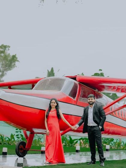 A classic couple's portrait in front of the red airplane, a standout feature of our venue.
