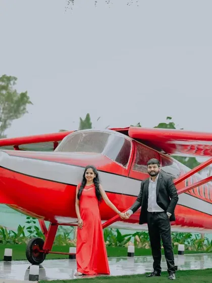 A classic couple's portrait in front of the red airplane, a standout feature of our venue.