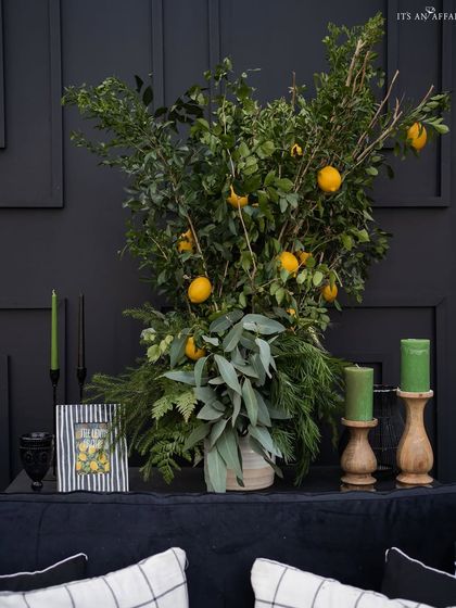 A close-up of the decor details, where fresh lemons and greenery are paired with candles and a custom-framed print to enhance the theme.