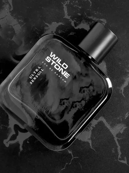 A sleek, monochrome shot of Wild Stone perfume on a black marble surface. This minimalist and high-contrast style communicates sophistication and is ideal for luxury men's grooming products.