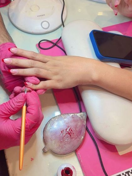 A behind-the-scenes look at the detailed process of creating perfect red French tips.