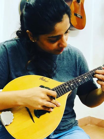 A student learns to play the mandolin, a beautiful stringed instrument with a bright, ringing tone. We teach techniques for playing both melodies and chords.