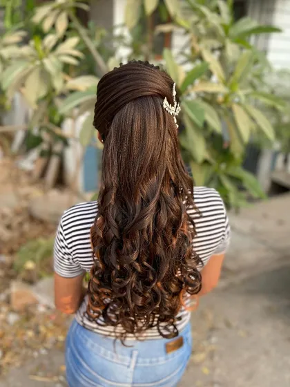 The full view of the advanced curly ponytail. It's a glamorous and sophisticated style that keeps hair off the face while still having lots of volume and movement.