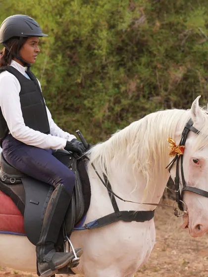 A female rider looking focused and confident on a trail ride. Our safaris are for everyone who is ready for an adventure.