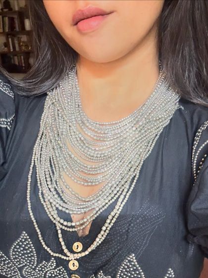 A close-up of the stunning multi-layered silver bead necklace. This is a perfect example of a 'minimal maximalist' accessory.